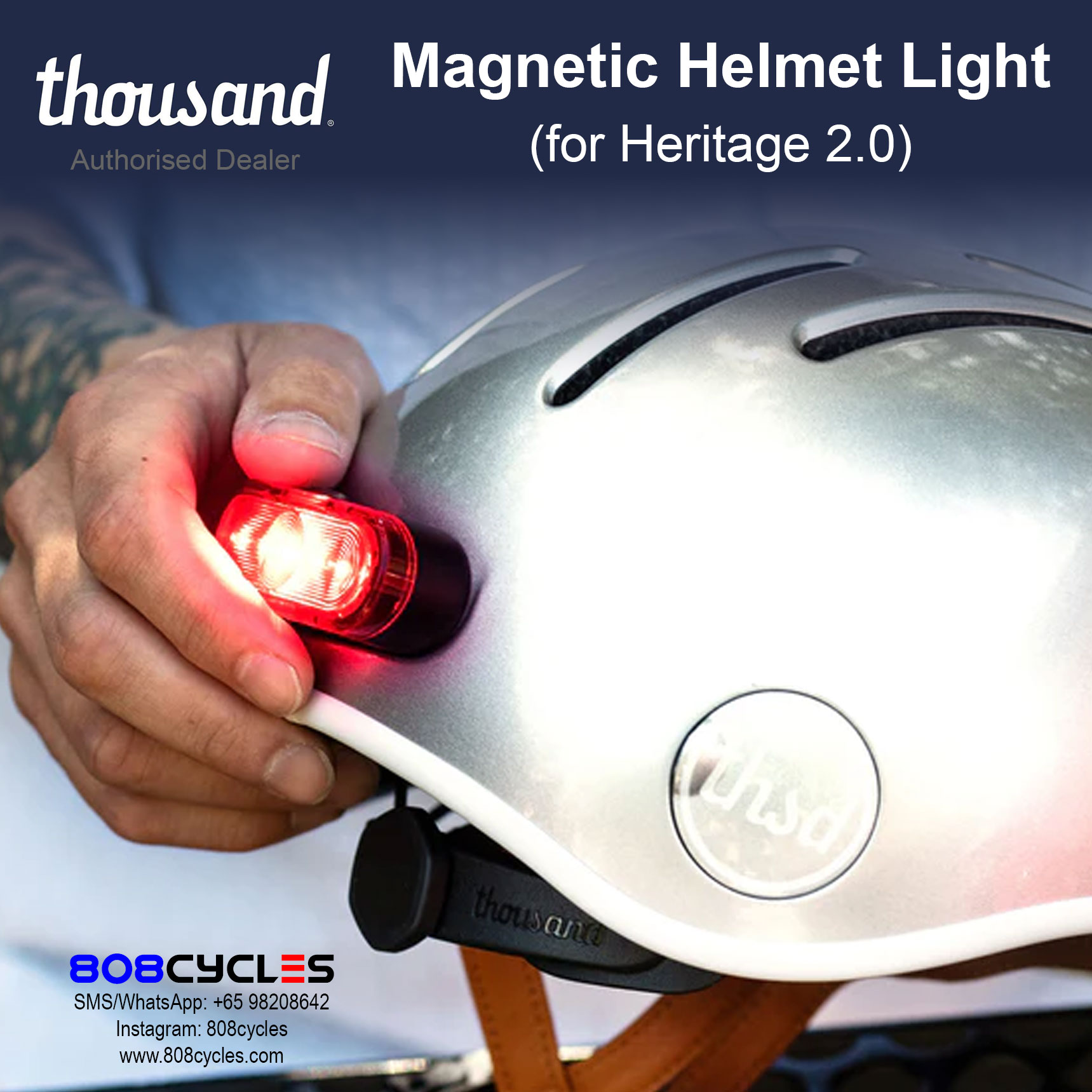 Hand attaching an illuminated Thousand Magnetic Helmet Light to a silver Heritage 2.0 helmet