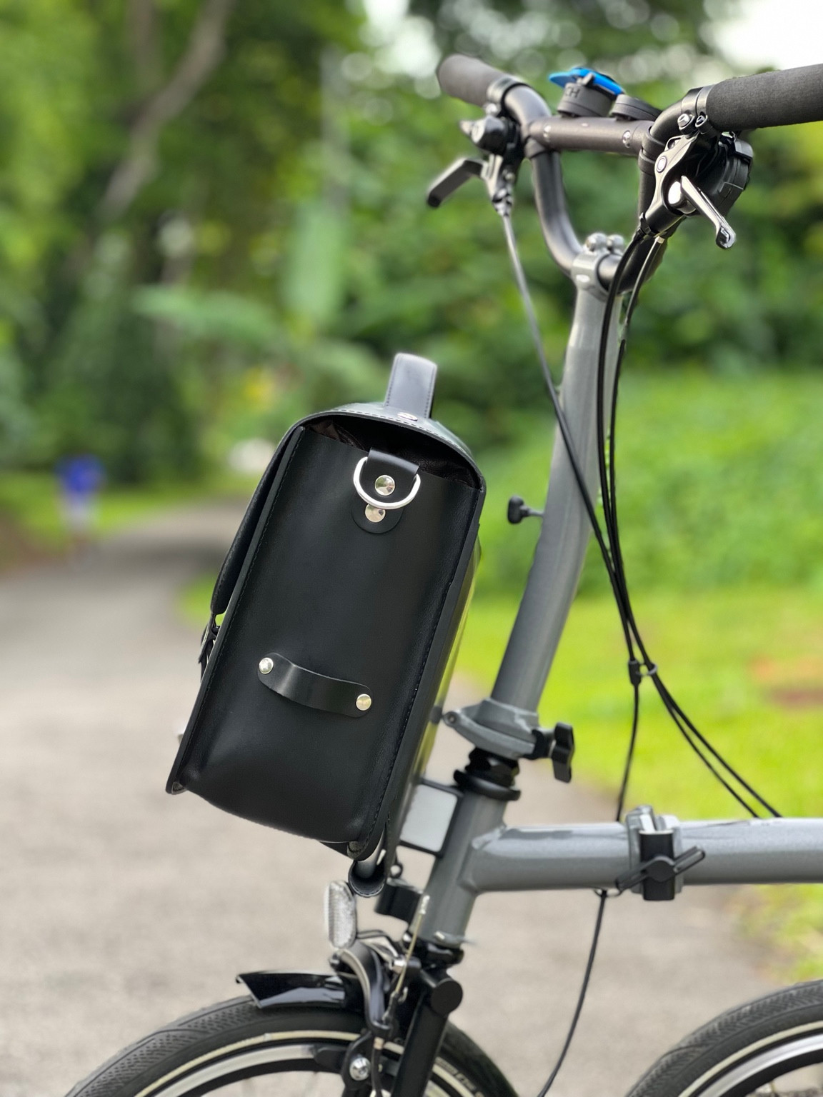 Side view of black Souma Leather camera bag showing D-ring and strap holder