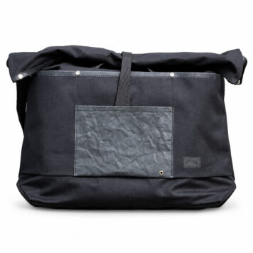 Black La Jefa & Sons CORDURA shopping tote on a white background, showing its front pocket and folded top